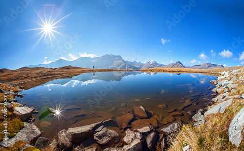 Doppelter Sonnenschein auf einen kleinen Bergsee in Sportgastein photo