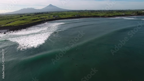 Aerial view of surfing volcanic reef waves on the Taranaki coastline, New Zealand