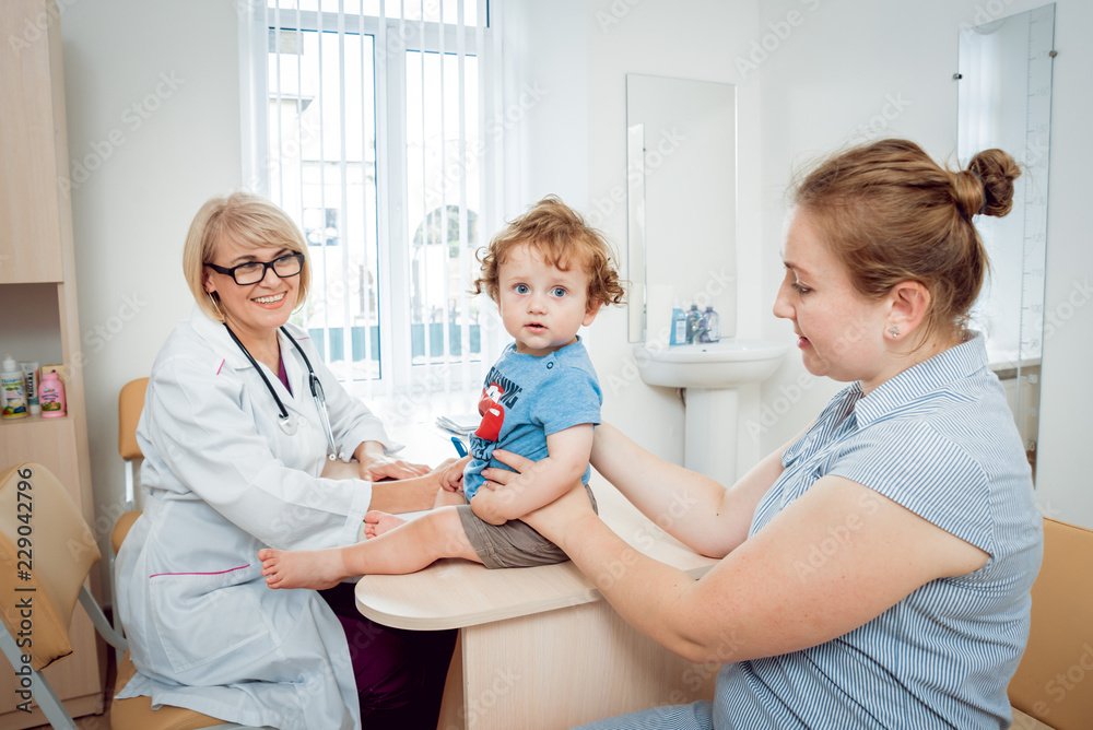 Friendly doctor pediatrician with patient child at clinic Friendly doctor pediatrician with patient child at clinic