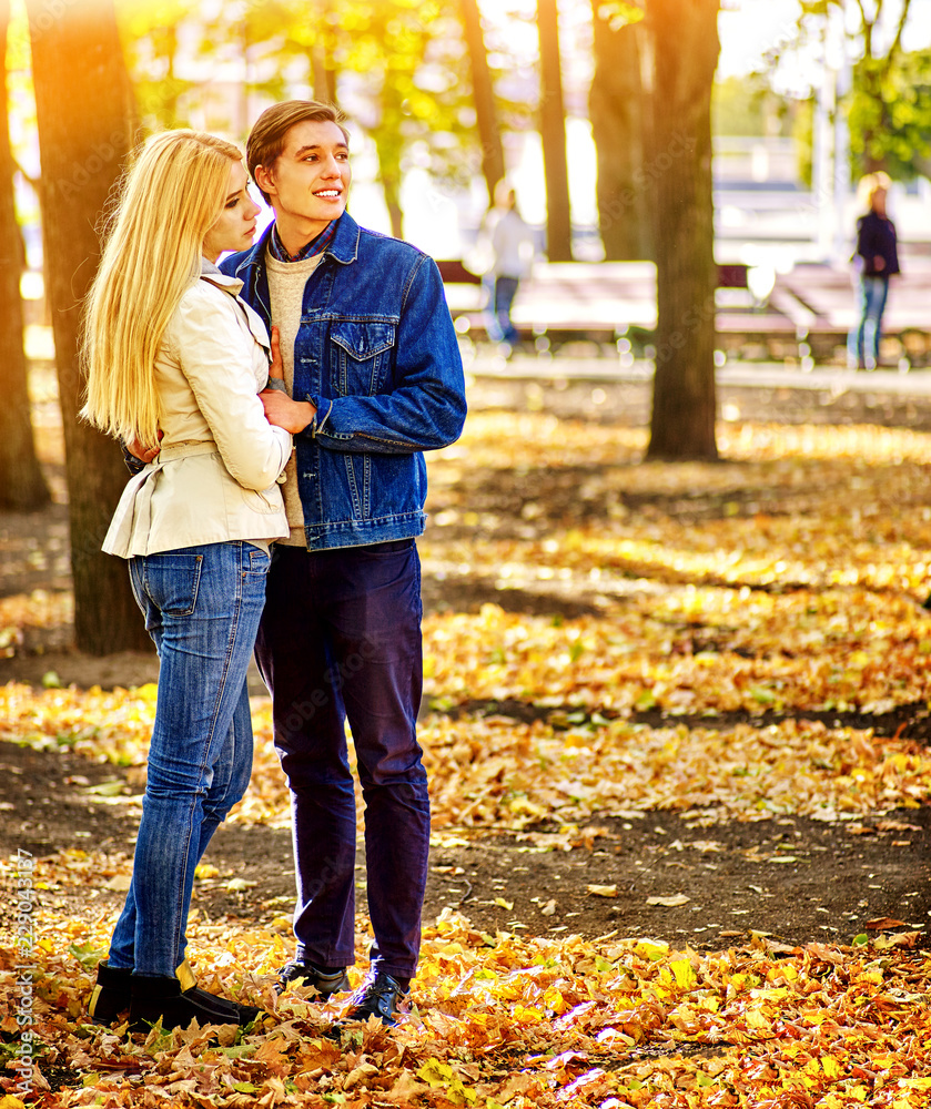 Couple in love into autumn fall city park outdoor. Man and woman with  flower hug under tree. People and bench on background. Stock Photo | Adobe  Stock