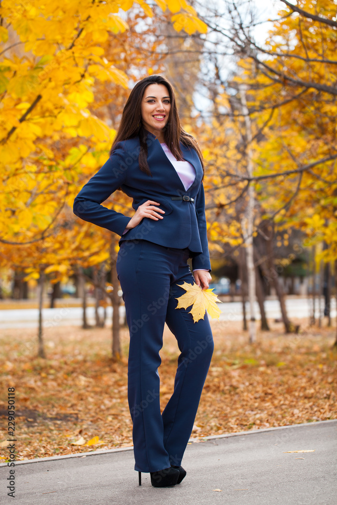 Happy arab businesswoman in blue suit walking in autumn park Happy arab businesswoman in blue suit walking in autumn park