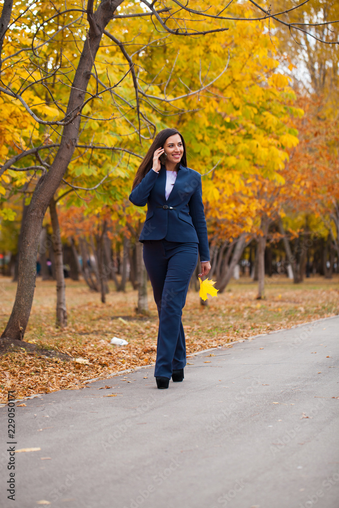 Happy arab businesswoman in blue suit walking in autumn park Happy arab businesswoman in blue suit walking in autumn park