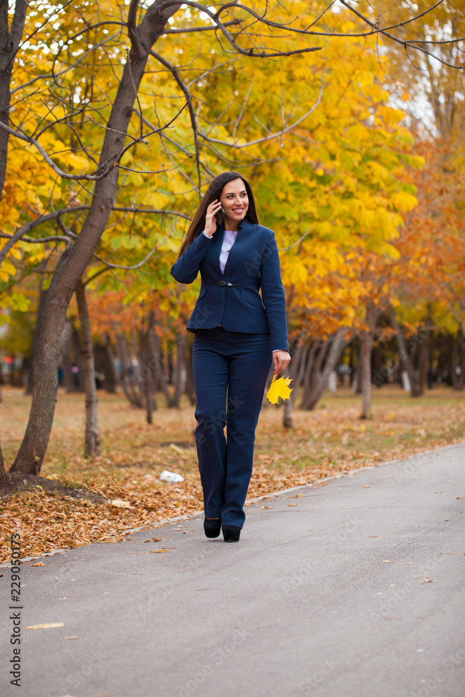 Happy arab businesswoman in blue suit walking in autumn park Happy arab businesswoman in blue suit walking in autumn park