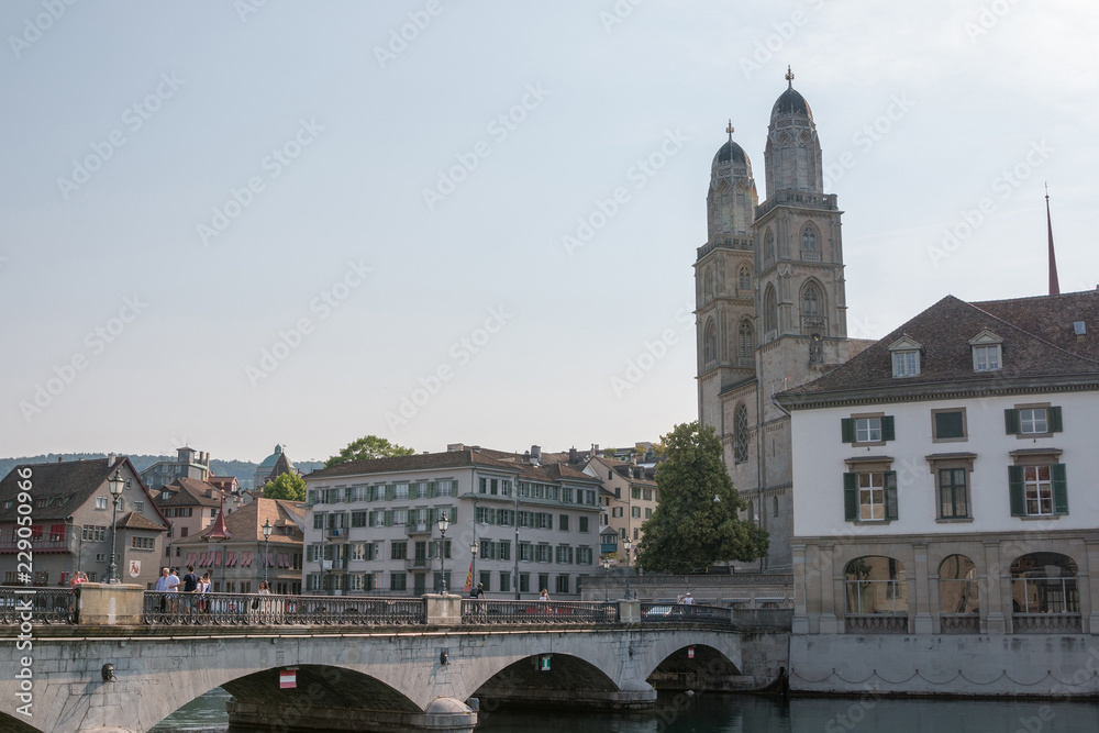 Zurich, Switzerland - June 19, 2017: Panoramic view of historic Zurich city center with famous Grossmunster Church and river Limmat. Summer landscape, sunshine weather, blue sky and sunny day