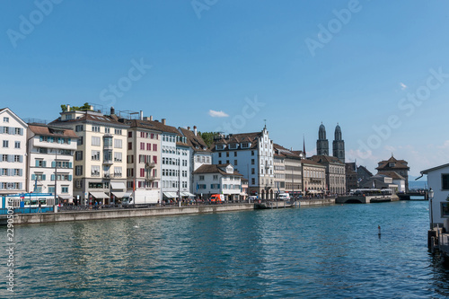 Zurich, Switzerland - June 19, 2017: Panoramic view of historic Zurich city center with famous Grossmunster Church and river Limmat. Summer day with blue sky