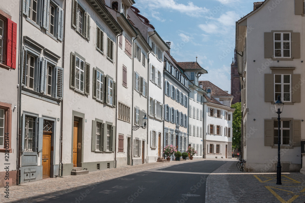 Basel, Switzerland - June 19, 2017: Walk through old buildings in historic center of Basel city. Summer day with blue sky