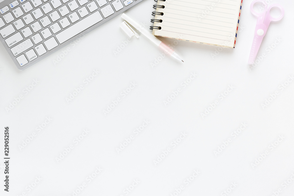 Top or above view / flat lay of office supply on designer desk table, business / personal work space, scissors, desktop keyboard, pen, blank opened diary, empty space for text or schedule. White theme Top or above view / flat lay of office supply on designer desk table, business / personal work space, scissors, desktop keyboard, pen, blank opened diary, empty space for text or schedule. White theme
