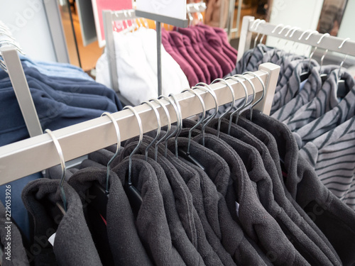 Wear hanging on rack in clothing store.