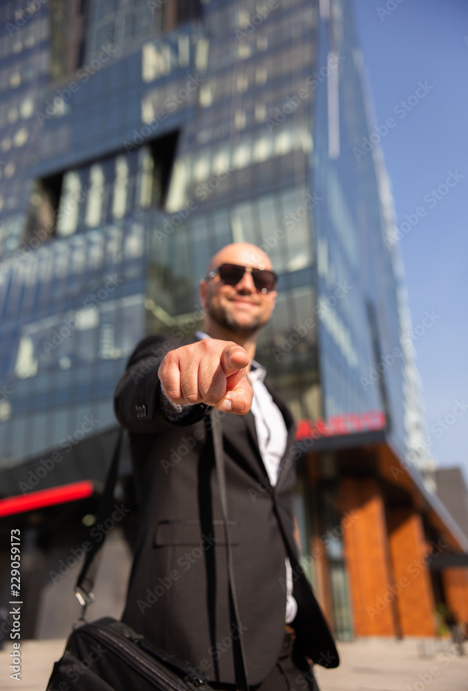 Handsome elegant businessman with sunglasses in front of office building Handsome elegant businessman with sunglasses in front of office building
