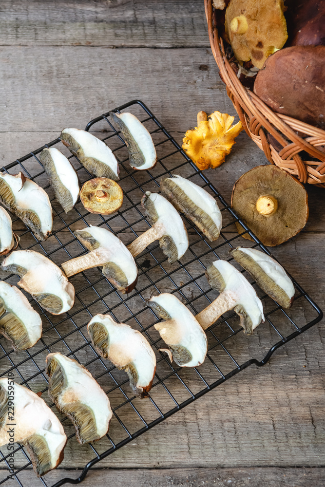Fototapeta premium Drying fresh forest mushrooms on wooden table.