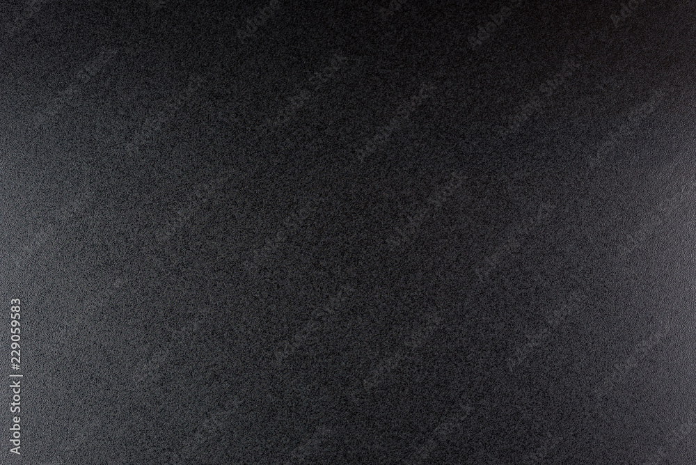 Black, rough textured background lit with dim light. Black, rough textured background lit with dim light.