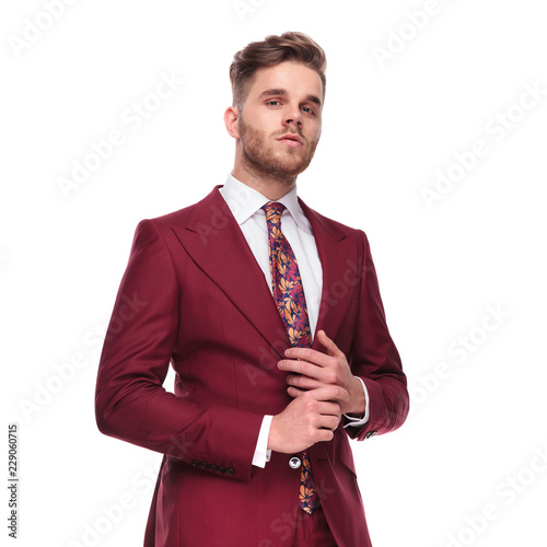 portrait of proud man in elegant suit arranging his ring photo