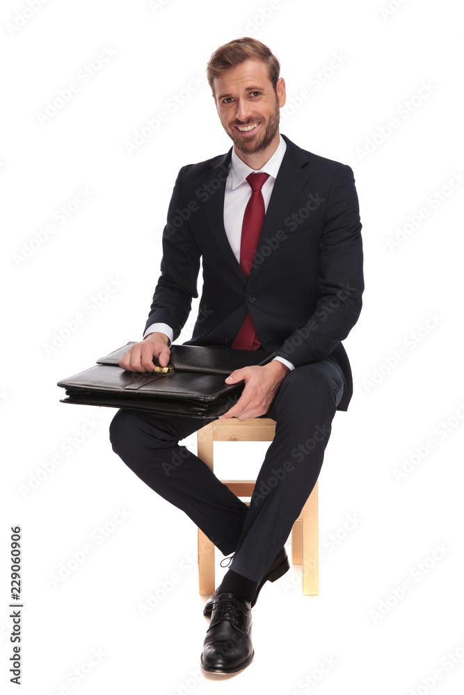 seated businessman waiting for job interview and opening suitcase