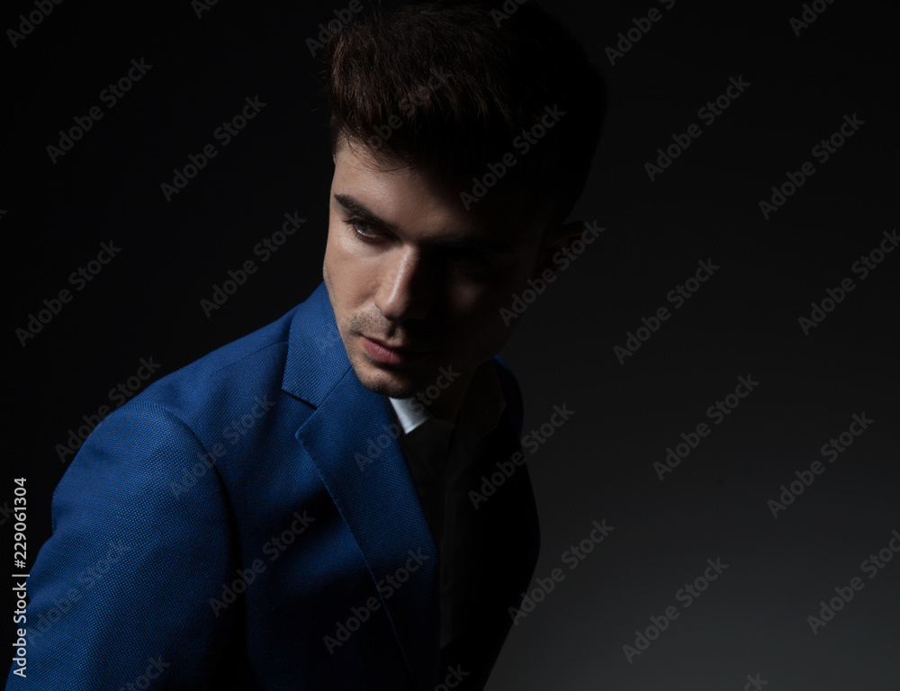 portrait of attractive smart casual man looking down and behind