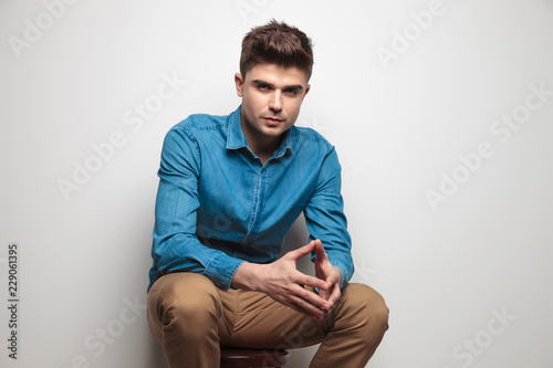 attractive casual man sitting and holding palms together © Viorel Sima