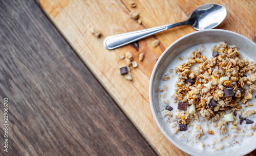 Bowl of chocolate muesli and milk on dark background