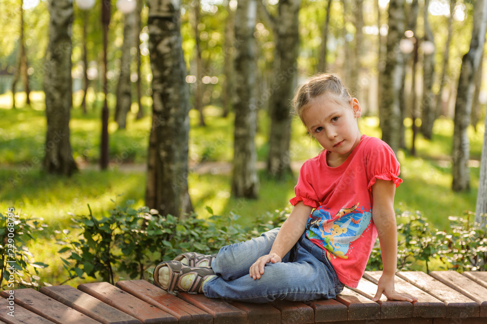 little boy sitting on a bench in autumn park little boy sitting on a bench in autumn park
