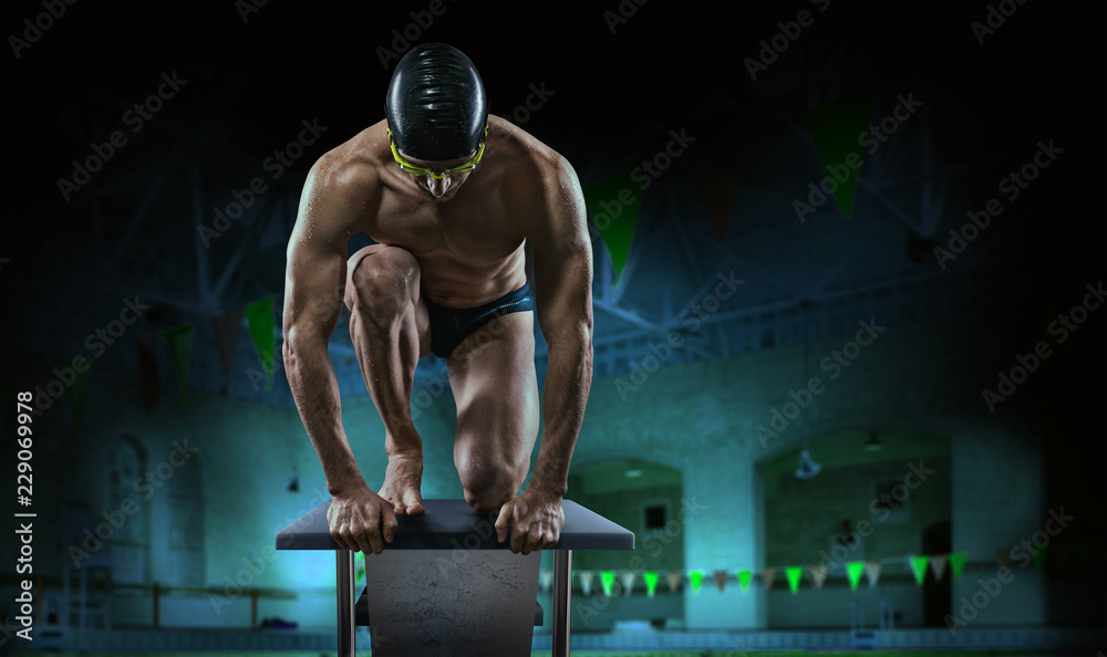 Swimming pool. Muscular swimmer ready to jump. - obrazy, fototapety, plakaty 