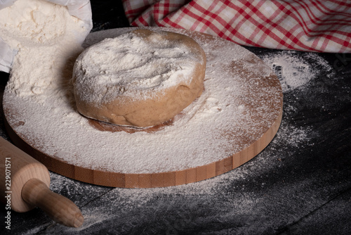 Fotografie Dough on a floury wooden plate