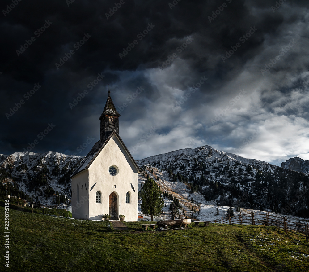 Small chapel with mountains in the background Small chapel with mountains in the background