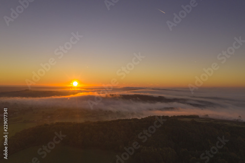Misty morning sunrise in the English countryside aerial shot.