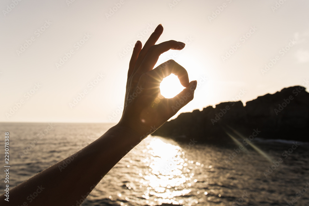 finger all is well on the sea. mark of approval. hand gestures, sun in hands