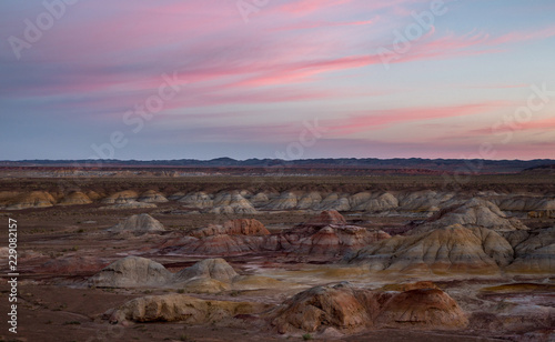 Rainbow Hills in China. Rainbow City  Wucai Cheng. Colorful layered landforms in a remote desert area of Fuyun County. Uygur Autonomous Region  Xinjiang Province. Sunrise - Pink  Purple and Blue Sky