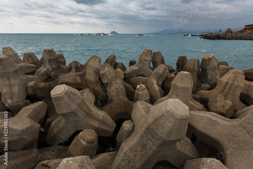 Tetrapod concrete blocks protecting a seawall along the coastline in Yehliu, near Taipei Taiwan. Assortment of interlocked tetrahedral shapes and strong ocean waves. Coastal Engineering Structure