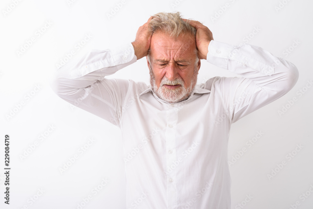Studio shot of stressed senior bearded man thinking while having Studio shot of stressed senior bearded man thinking while having