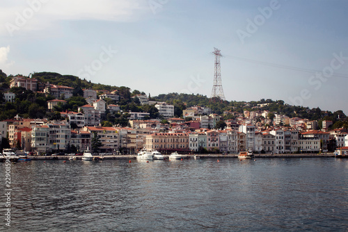 View of motorboats and yachts, buildings on European side and Bosphorus in Istanbul. It is a sunny summer day.