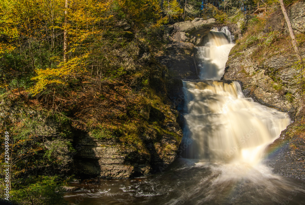 Beautiful autumn waterfall at Delaware Water Gap National Recreation Area in Pennsylvania with fading rainbow
