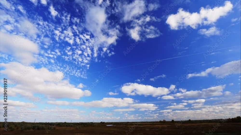 4K Light clouds in a blue sky over a field. Windy autumn sky. 4K Light clouds in a blue sky over a field. Windy autumn sky.