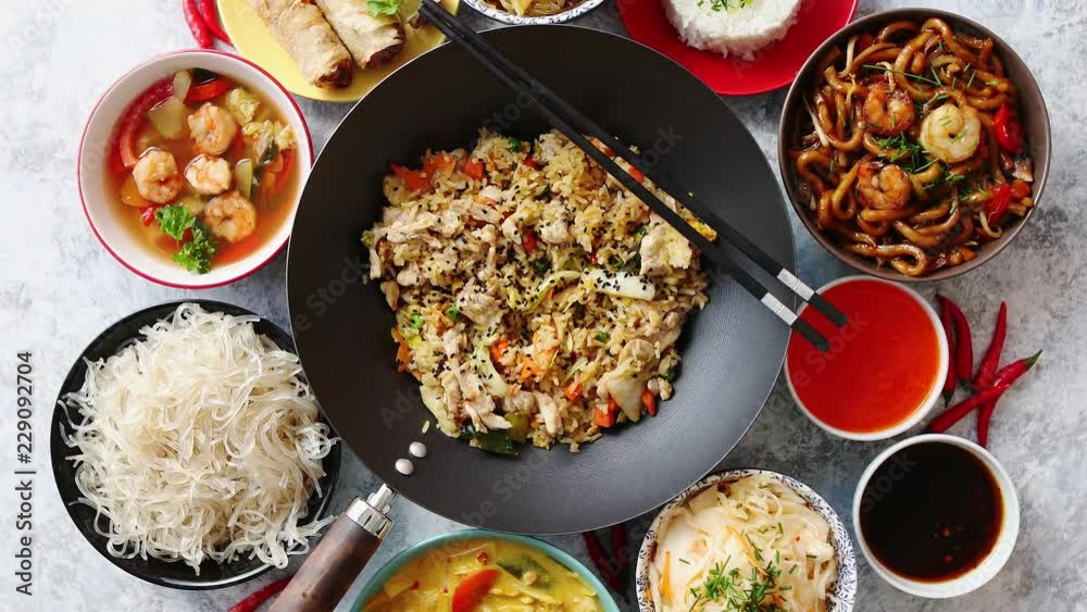 Chinese food set. Chinese noodles, fried rice with chicken, tom yum soup, spring rolls, deep fried fish and udon. Top view. Asian style food concept composition.