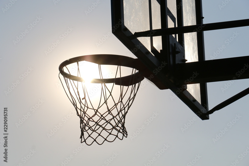 Naklejka premium Basketball hoop on basketball court under syn