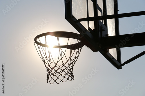 Basketball hoop on basketball court under syn © Željko Radojko
