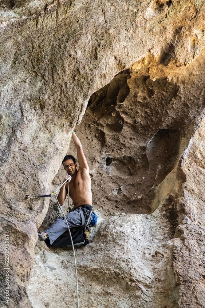 The last movements to reach the summit by a male climber. Rock climbing inside Andes mountains and valleys at Cajon del Maipo, an amazing place to enjoy rock climbing and mountaineering sports, Chile
