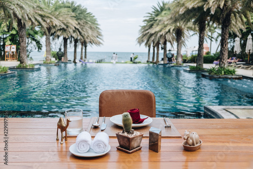 Table And Chair with Blur Swimming Pool Of The Background. Summer Vacation concept 