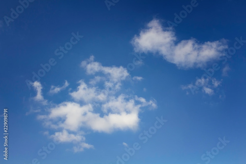View of small clouds with a blue sky background in a sunny summer day.