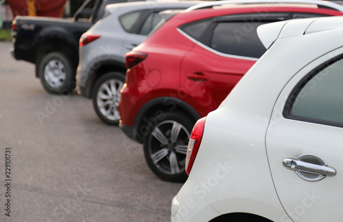 Closeup of rear side of white car park in parking area in the evening. 