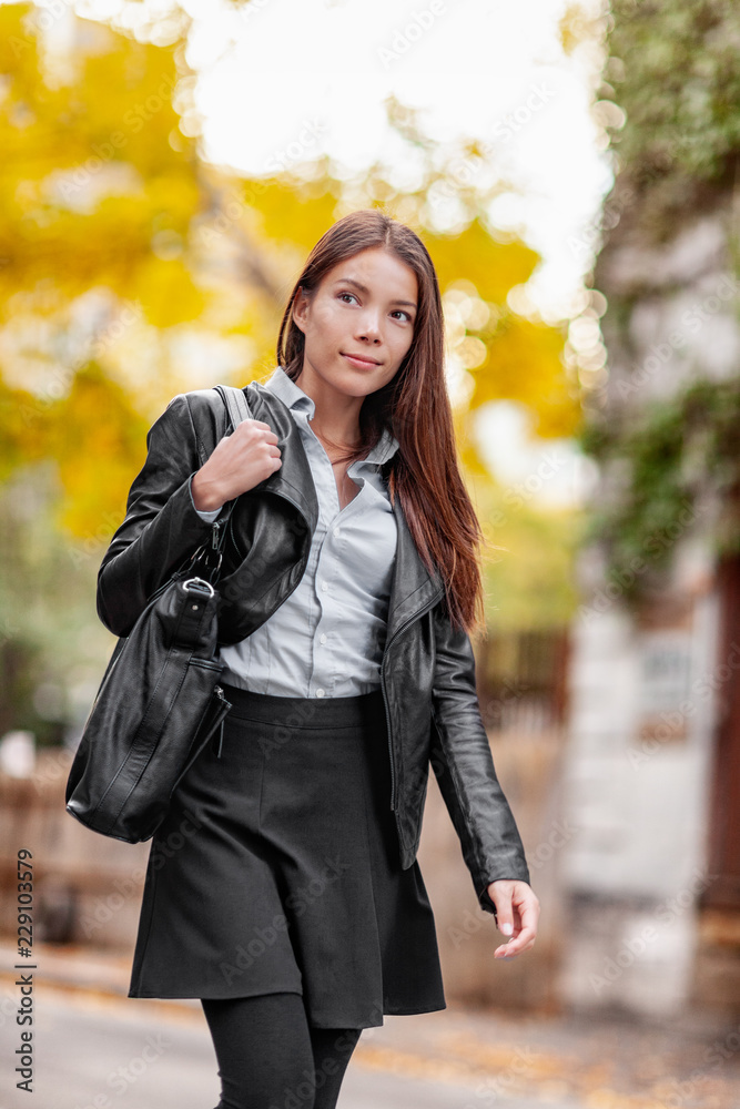 Young woman walking in city street, autumn lifestyle wearing fashion outfit clothing. urban professional girl in black leather jacket, leggings, skirt, boots. Trendy modern multiracial Asian model. Young woman walking in city street, autumn lifestyle wearing fashion outfit clothing. urban professional girl in black leather jacket, leggings, skirt, boots. Trendy modern multiracial Asian model.