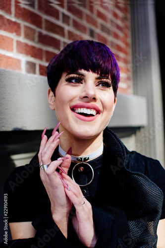 Portrait of a smiling young girl with short purple hair and very long nails
