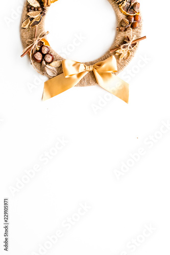 Creative, unusual christmas wreath made of thread, dry fruits and nuts on white background top view copy space