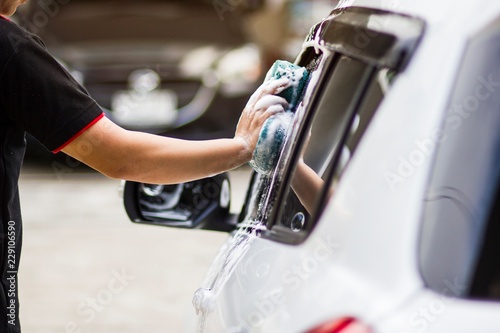 Use your right hand to catch the sponge and polish the car window. Concept car wash.