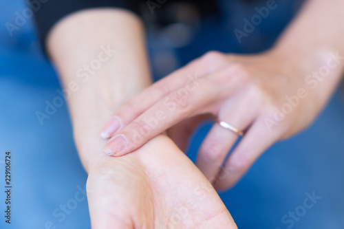 Woman checking pulse or heart rate with hand