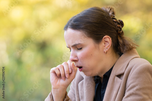Young woman coughing or sneezing