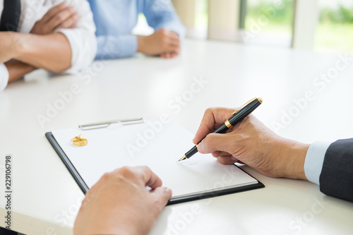 Angry couple arguing telling their problems to Judge gavel deciding on marriage to conclude an agreement on the divorce. They quarrel and argue with each other