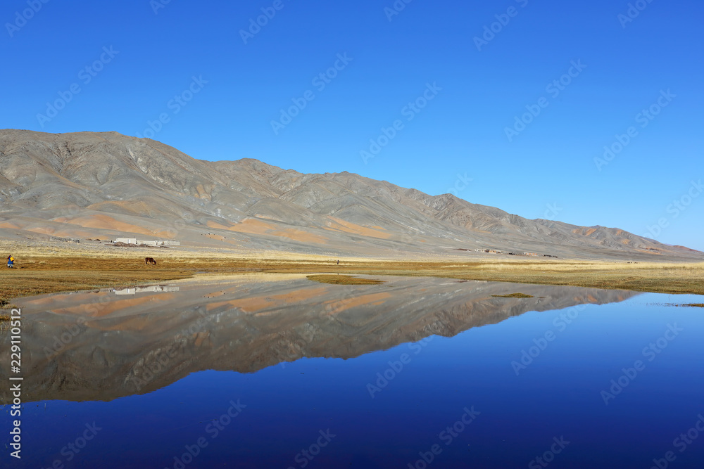 Reflection of lake after beautiful mountain with blue sky of Western Mongolia. Natural background	