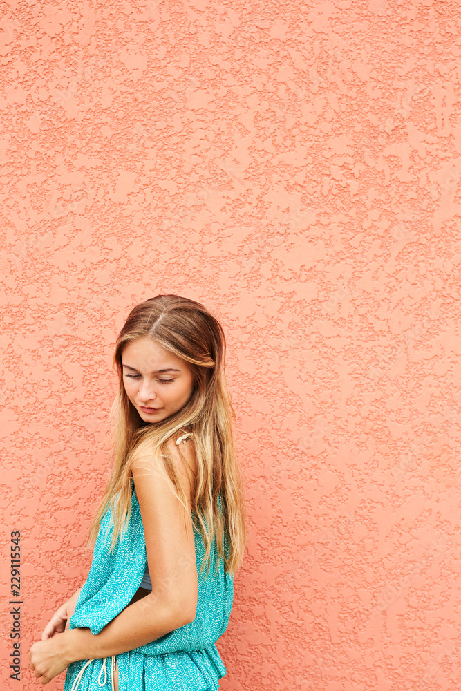 Beautiful blond girl by wall, looking down Beautiful blond girl by wall, looking down