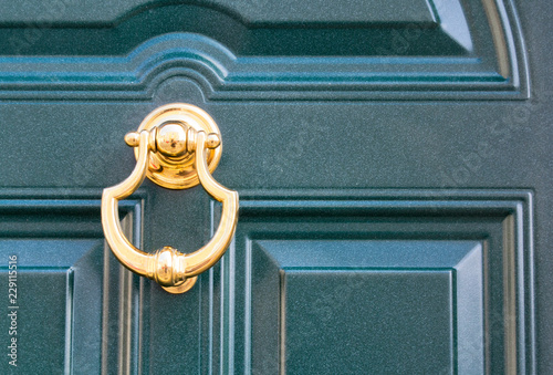 08 09 2018 Atri, Italy - golden door knocker on a traditional dark door photo