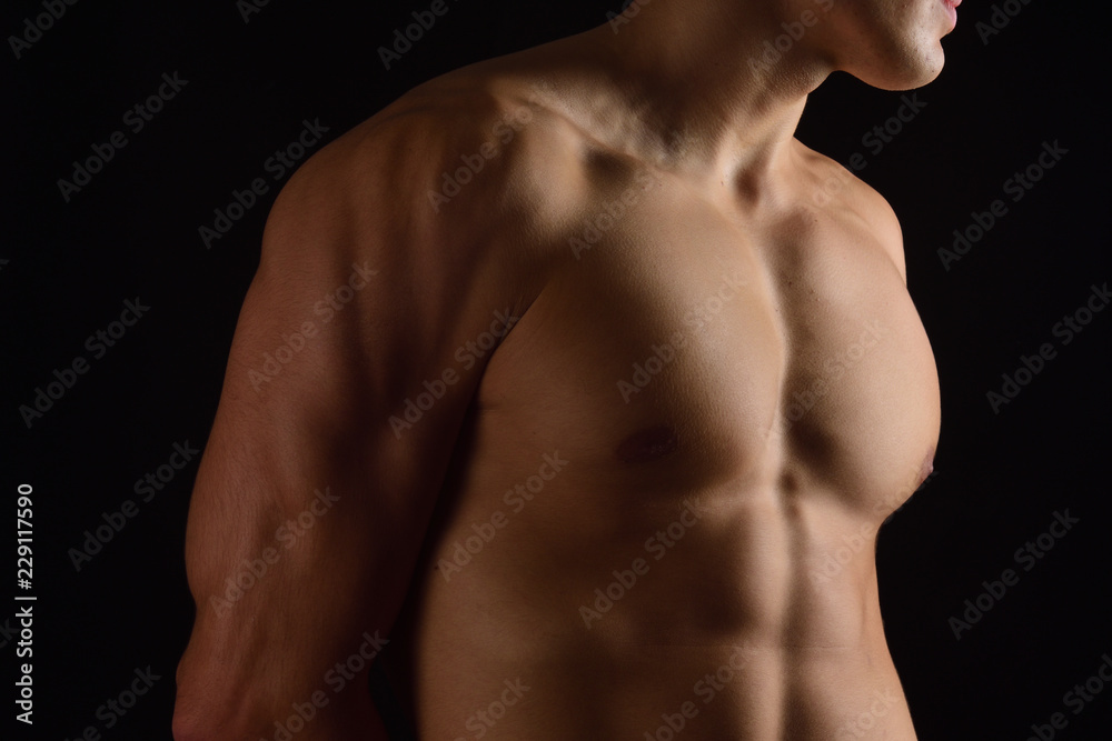 naked breast of a man on black background